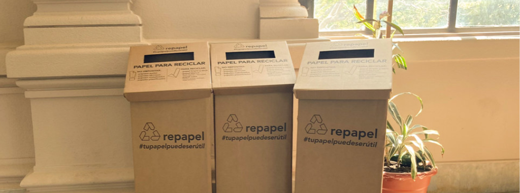 Fotografía. Tres tachos hechos de cartón con el simbolo de reciclaje y el texto repapel #tupapelpuedeserútil.